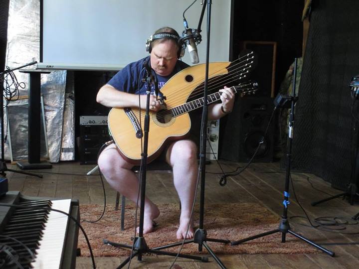 photo of Jim in the recording studio with his harp guitar